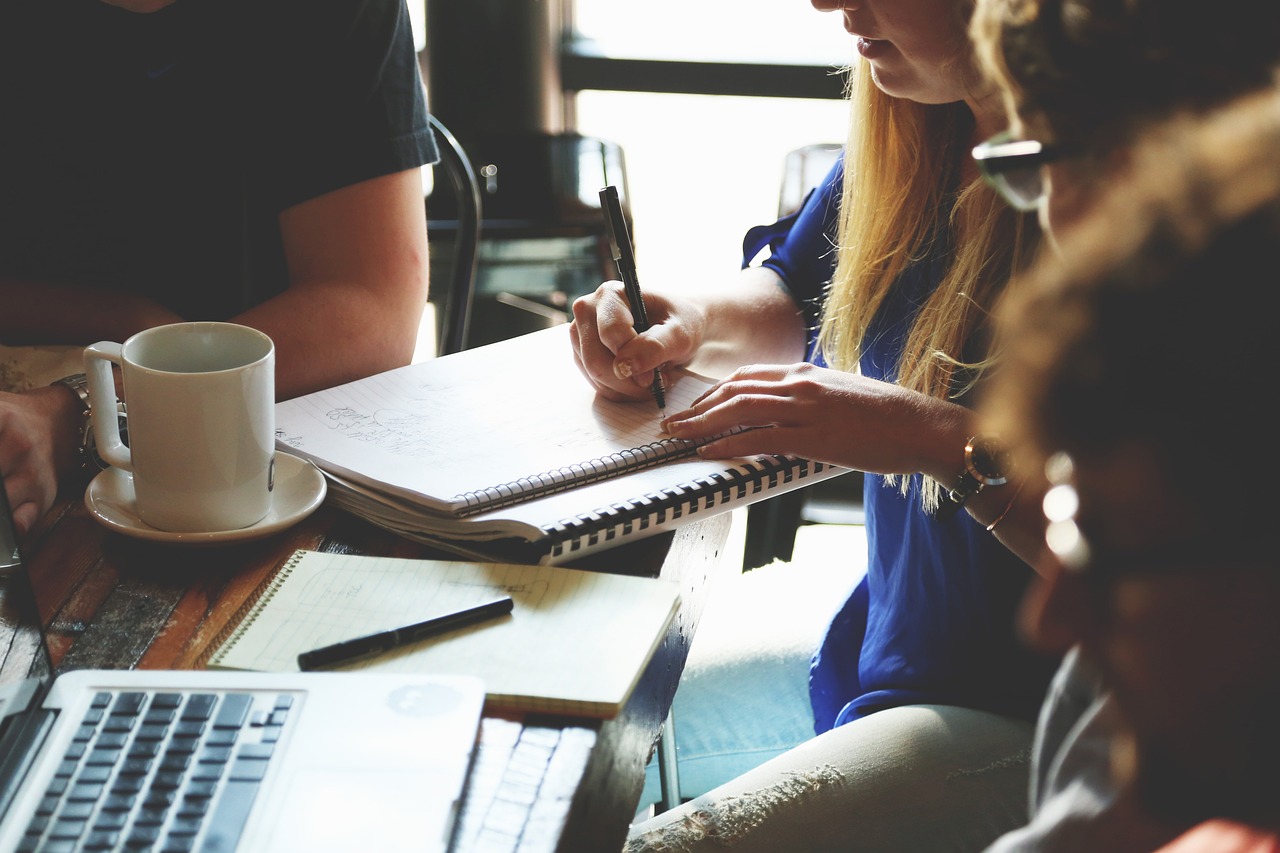 people working together around a desk with laptop and notes