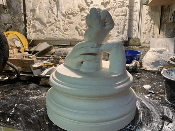 A ceramic sculpture of a hand holding a fist 